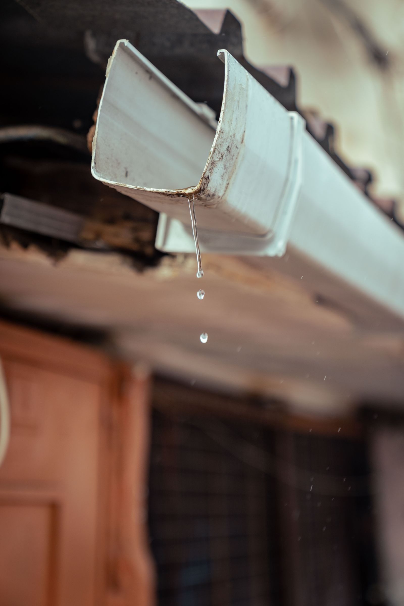 Rainwater dripping from a white uPVC gutter